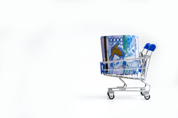 Tenge. Kazakh money in shopping cart on white background close-up. 