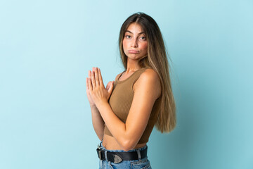 Young caucasian woman isolated on blue background scheming something
