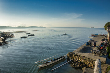 Fishing boat harbor. Bulalacao, the Philippines.  Banka fishing boat heading out to the fishing grounds. Beautiful setting but over fishing of small fish is creating an ecological disaster.