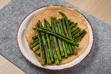 A plate of baked asparagus on parchment paper