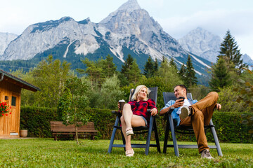 Obraz premium Young lovers relaxing on holiday in beautiful panorama with mountains Bavaria Germany. Couple in love relaxing in spring
