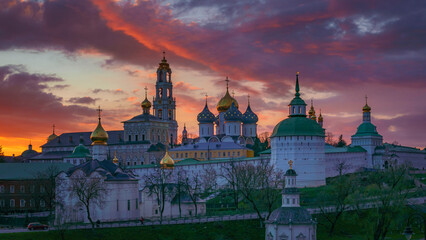 Beautiful sunset sky with pink, red, orange and purple clouds over old churches 