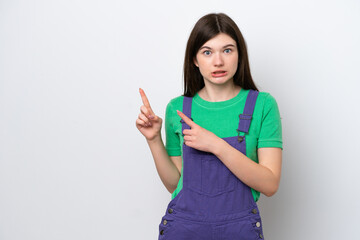 Young Russian woman isolated on blue background frightened and pointing to the side