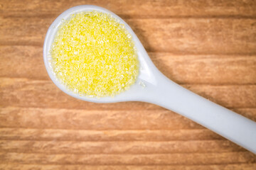Confectionary yellow sugar in a white spoon