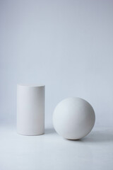 white ball and cylinder on a white background with shadows