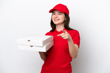 Young Russian pizza delivery picking up pizza boxes isolated on white background pointing front...