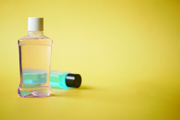 mouthwash liquid in a container on yellow background 