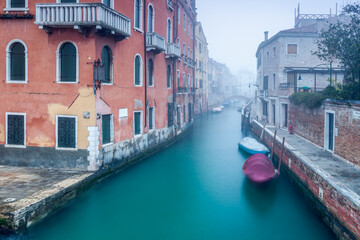 Small canal in Venice on a foggy winter day