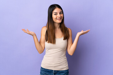 Young caucasian woman isolated on purple background with shocked facial expression