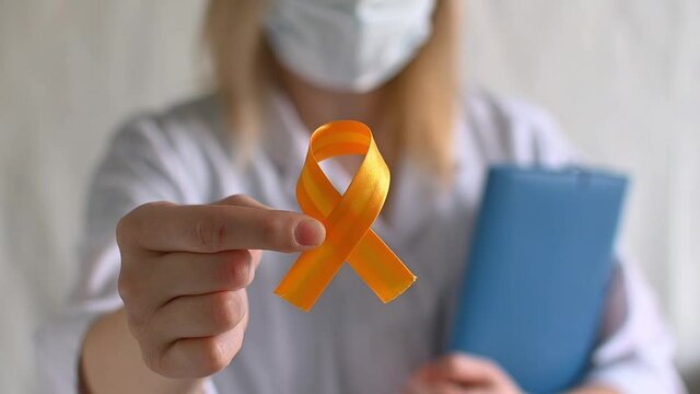 International Childhood Cancer Day. Female doctor in white coat holds yellow ribbon. Sarcoma Awareness, bladder cancer. Leukemia cancer awareness. World Multiple Sclerosis day. I Am and I Will. FullHD