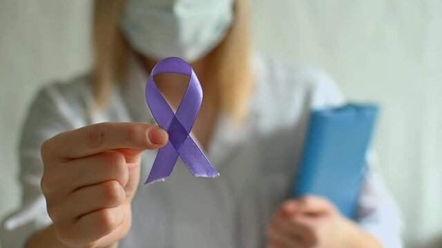International Epilepsy Day. Doctor in coat holds purple ribbon on white background. Alzheimer's disease, Pancreatic cancer, Hodgkin's Lymphoma awareness. World Lupus Day. I Am and I Will.