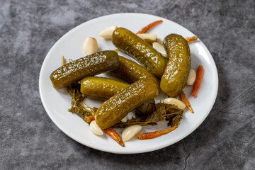 Pickled cucumbers on dark background. Close-up of pickled cucumbers in a ceramic plate. close up.