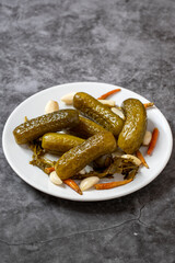Pickled cucumbers on dark background. Close-up of pickled cucumbers in a ceramic plate. close up.