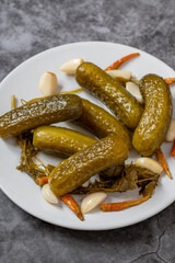 Pickled cucumbers on dark background. Close-up of pickled cucumbers in a ceramic plate. close up.