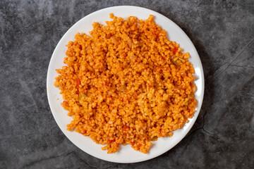 Bulgur pilaf on a dark background. Close-up of Turkish food Bulgur Pilav in a ceramic plate. Top view