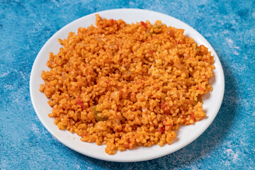 Bulgur pilaf on a blue background. Close-up of Turkish food Bulgur Pilav in a ceramic plate