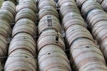 Old stacked wooden barrels with a rustic look that are tied together for transport