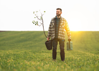The yound gardener is going to plant a tree in the field