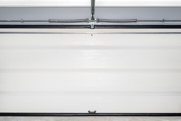 A closed garage door with an electric drive, four sections, a view straight from the inside of the...