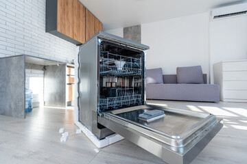 Open integrated dishwaher machine in a modern kitchen