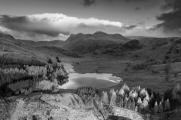 Black and white Beautiful aerial drone landscape image of sunrise from Blea Tarn in Lake District during stunning Autumn showing