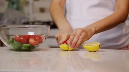 Pregnant woman Cutting a lemon for a salad. Healthy food concept. 