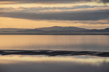 Beautiful sunset landscape image of Solway Firth viewed from Silloth during stunning Autumn sunset with dramatic sky and cloud formations