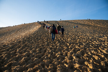 People climbing to the top of Dune of Pilat, tallest sand dune in Europe, located in Arcachon Bay...