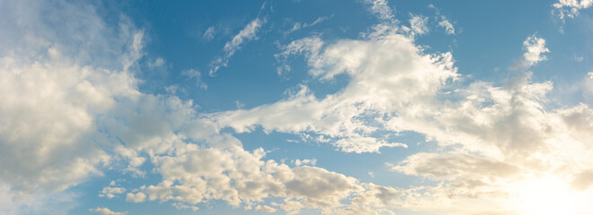 Scenic sky background with sunlight and clouds. Beautiful panoramic background of atmosphere. Wide-angle image for design work