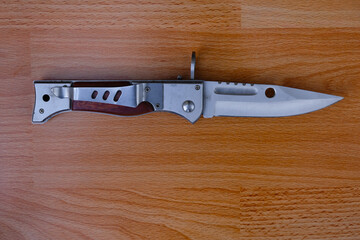 Combat knife on wooden background. Bayonet knife from AK-47 Kalashnikov assault rifle.