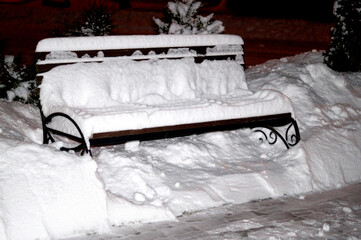 benches in a city park under a layer of snow