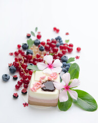Fototapeta na wymiar A scattering of juicy berries, flowers and a soufflй cake.