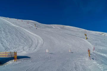 Fotobehang Panoramic view of skiers skiing down slopes in the ski resort of Livigno, Italy © Jack Krier