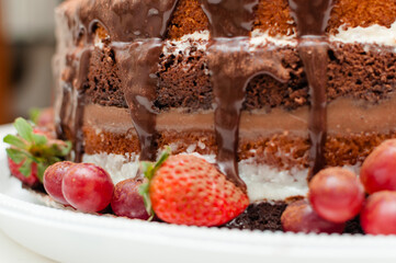 Detalhe da massa macia e o chocolate escorrendo do Bolo frutado com frutas naturais para comemorações e eventos especiais