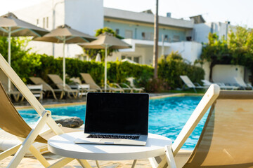 laptop computer on table pool background