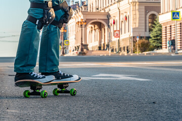 Legs of a man on a skateboard on the street