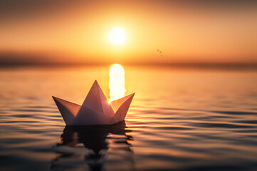 Papierschiffchen im Sonnenuntergang