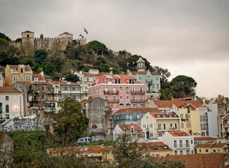 Fototapeta na wymiar Apartment window view of the hillside of Mouraria neighborhood and the Castel of Saint George.