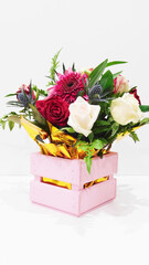 bouquet of beautiful flowers in a pink wooden box