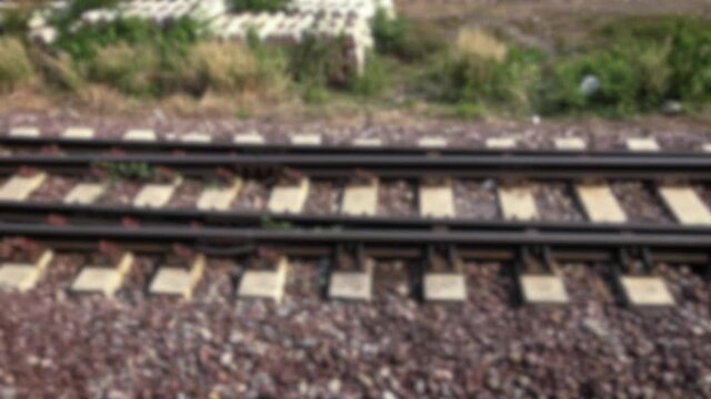 Defocused shot of rails transit train trip in countryside in Thailand. Blurred background in the scene 