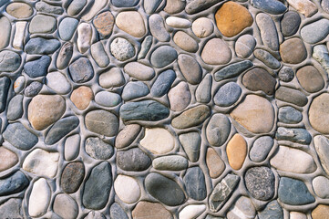 Background of stones. A wall of multicolored stones. Masonry on mortar cement mortar. A wall of large stones.