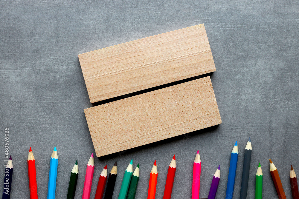 Aufkleber flat lay of wooden blocks on gray background with multicolored pencils with copy space. financial or