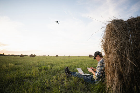 Farmer with laptop and drone on the field. Smart farming and agriculture digitalization	