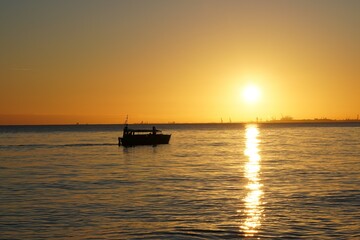 łódka na morzu o wschodzie słońca