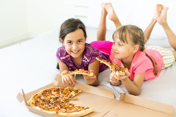 Attractive little girls posing with pizza boxes