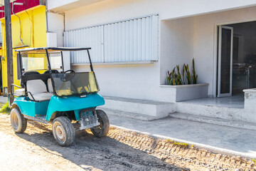 Golf cart buggy cars carts muddy street village Holbox Mexico.