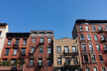 Row of Old Brick Apartment Buildings in the East Village of New York City with Fire Escapes