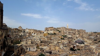 Fototapeta na wymiar ITALY-Matera is a city located on a rocky outcrop in Basilicata, in Southern Italy. It includes the Sassi area, a complex of Cave Houses carved into the mountain