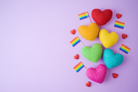 Happy Valentines day concept with heart shapes and rainbow flag on purple background. Flat lay composition