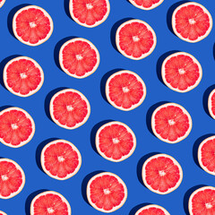 Minimal fruit pattern with grapefruit on blue  background. Creative  summer mood. Healty concept. Organic fruit. Flat lay. Trendy social mockup or wallpaper.